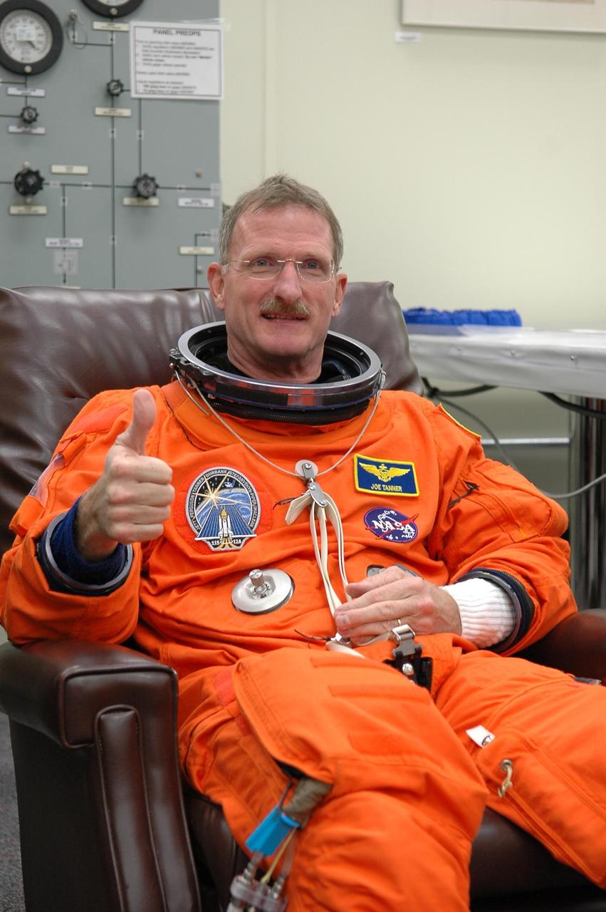 KENNEDY SPACE CENTER, FLA. - During suitup in the Operations and Checkout Building at NASA Kennedy Space Center, STS-115 Mission Specialist Joseph Tanner signals a "go" for another attempt at liftoff.   The launch attempt on Sept. 8 was scrubbed due to an issue with a fuel cut-off sensor system inside the external fuel tank. This is one of several systems that protect the shuttle's main engines by triggering their shutdown if fuel runs unexpectedly low.  During the STS-115 mission, Atlantis' astronauts will deliver and install the 17.5-ton, bus-sized P3/P4 integrated truss segment on the station. The girder-like truss includes a set of giant solar arrays, batteries and associated electronics and will provide one-fourth of the total power-generation capability for the completed station. This mission is the 116th space shuttle flight, the 27th flight for orbiter Atlantis, and the 19th U.S. flight to the ISS. STS-115 is scheduled to last 11 days with a planned landing at KSC.  Photo credit: NASA/Kim Shiflett