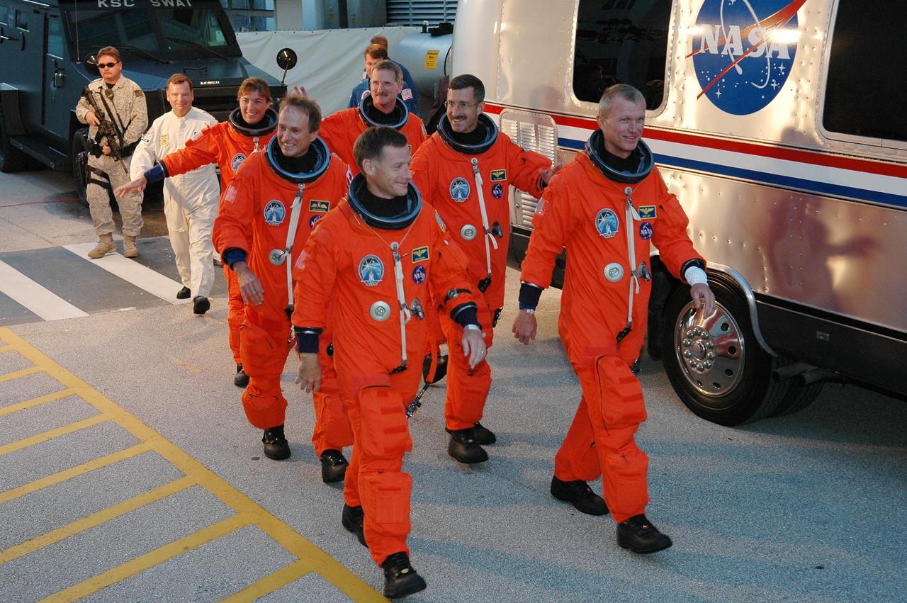 KENNEDY SPACE CENTER, FLA. -  The STS-115 mission crew happily heads to the Astrovan for the ride to Launch Pad 39B and another attempt at liftoff.  From the left, in the back row are Mission Specialists Heidemarie Stefanyshyn-Piper and Joseph Tanner; in the center row are Mission Specialists Steven MacLean and Daniel Burbank; in the front row leading the way are Pilot Christopher Ferguson and Commander Brent Jett.  The launch attempt on Sept. 8 was scrubbed due to an issue with a fuel cut-off sensor system inside the external fuel tank. This is one of several systems that protect the shuttle's main engines by triggering their shutdown if fuel runs unexpectedly low.  During the STS-115 mission, Atlantis' astronauts will deliver and install the 17.5-ton, bus-sized P3/P4 integrated truss segment on the station. The girder-like truss includes a set of giant solar arrays, batteries and associated electronics and will provide one-fourth of the total power-generation capability for the completed station. This mission is the 116th space shuttle flight, the 27th flight for orbiter Atlantis, and the 19th U.S. flight to the ISS. STS-115 is scheduled to last 11 days with a planned landing at KSC.  Photo credit: NASA/Kim Shiflett