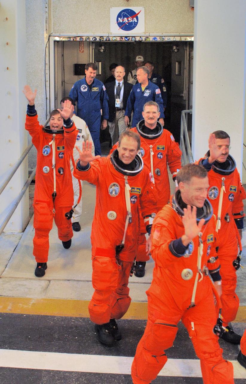 KENNEDY SPACE CENTER, FLA. - After suiting up, the STS-115 mission crew enthusiastically greet the onlookers as they head to the Astrovan for the ride to Launch Pad 39B.  From left are Mission Specialist Heidemarie Stefanyshyn-Piper, Steven MacLean, Joseph Tanner, Pilot Christopher Ferguson and Daniel Burbank.  Not seen is Commander Brent Jett.  The crew is eager for another attempt at liftoff after the Sept. 8 scrub.  The launch attempt on Sept. 8 was scrubbed due to an issue with a fuel cut-off sensor system inside the external fuel tank. This is one of several systems that protect the shuttle's main engines by triggering their shutdown if fuel runs unexpectedly low.  During the STS-115 mission, Atlantis' astronauts will deliver and install the 17.5-ton, bus-sized P3/P4 integrated truss segment on the station. The girder-like truss includes a set of giant solar arrays, batteries and associated electronics and will provide one-fourth of the total power-generation capability for the completed station. This mission is the 116th space shuttle flight, the 27th flight for orbiter Atlantis, and the 19th U.S. flight to the ISS. STS-115 is scheduled to last 11 days with a planned landing at KSC.  Photo credit: NASA/Kim Shiflett