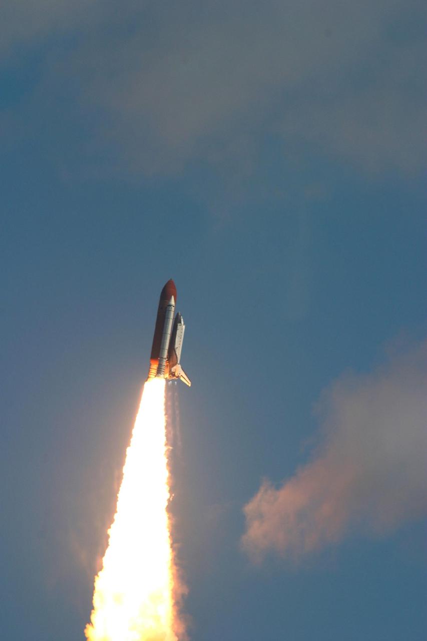 KENNEDY SPACE CENTER, FLA. - Looking like a work of art, Space Shuttle Atlantis roars into the blue Florida sky atop a column of fire for a rendezvous with the International Space Station on mission STS-115. After launch attempts were scrubbed Aug. 27 and 29 and Sept. 3 and 8 due to weather and technical concerns,  this launch was executed perfectly.  During the STS-115 mission, Atlantis' astronauts will deliver and install the 17.5-ton, bus-sized P3/P4 integrated truss segment on the station. The girder-like truss includes a set of giant solar arrays, batteries and associated electronics and will provide one-fourth of the total power-generation capability for the completed station. This mission is the 116th space shuttle flight, the 27th flight for orbiter Atlantis, and the 19th U.S. flight to the ISS. STS-115 is scheduled to last 11 days with a planned landing at KSC.  Photo credit: NASA/Dennis Sabo