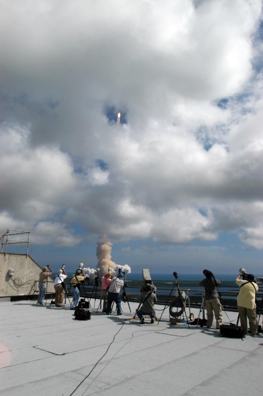 KENNEDY SPACE CENTER, FLA. - A phalanx of photographers line the roof of the Vehicle Assembly Building as Space Shuttle Atlantis roars off the launch pad at 11:14:55 a.m. EDT for a rendezvous with the International Space Station on mission STS-115. After launch attempts were scrubbed Aug. 27 and 29 and Sept. 3 and 8 due to weather and technical concerns,  this launch was executed perfectly.  During the STS-115 mission, Atlantis' astronauts will deliver and install the 17.5-ton, bus-sized P3/P4 integrated truss segment on the station. The girder-like truss includes a set of giant solar arrays, batteries and associated electronics and will provide one-fourth of the total power-generation capability for the completed station. This mission is the 116th space shuttle flight, the 27th flight for orbiter Atlantis, and the 19th U.S. flight to the ISS. STS-115 is scheduled to last 11 days with a planned landing at KSC.  Photo credit: NASA/George Shelton
