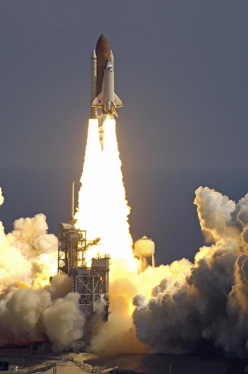KENNEDY SPACE CENTER, FLA. - Flaming rockets propel Space Shuttle Atlantis into the sky for a rendezvous with the International Space Station on mission STS-115.  Liftoff was on-time at 11:14:55 a.m. EDT.  After launch attempts were scrubbed Aug. 27 and 29 and Sept. 3 and 8 due to weather and technical concerns,  this launch was executed perfectly.  Mission STS-115 is the 116th space shuttle flight, the 27th flight for orbiter Atlantis, and the 19th U.S. flight to the International Space Station. During the mission, Atlantis' astronauts will deliver and install the 17.5-ton, bus-sized P3/P4 integrated truss segment on the station. The girder-like truss includes a set of giant solar arrays, batteries and associated electronics and will provide one-fourth of the total power-generation capability for the completed station. STS-115 is scheduled to last 11 days with a planned landing at KSC. Photo courtesy of Nikon/Scott Andrews