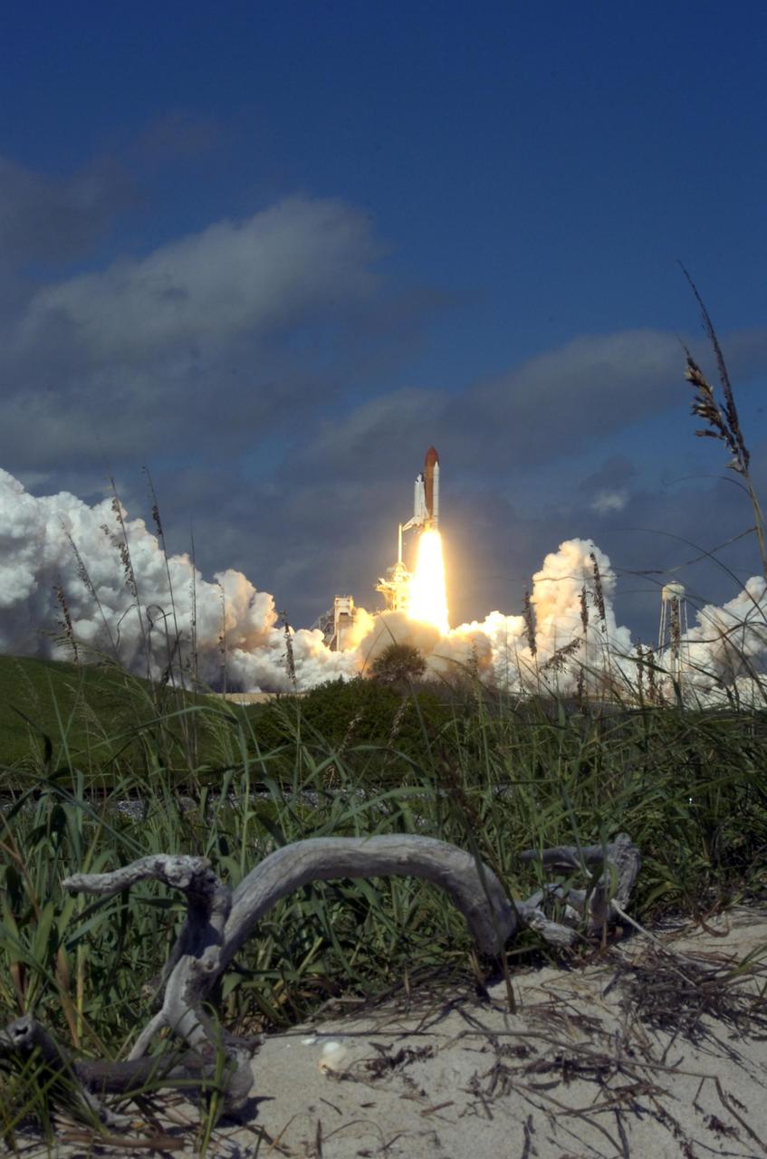 KENNEDY SPACE CENTER, FLA. -  The primitiveness of the dunes (foreground) clash with the technology exhibited in the launch of Space Shuttle Atlantis for its rendezvous with the International Space Station on mission STS-115.  Liftoff was on-time at 11:14:55 a.m. EDT.  After launch attempts were scrubbed Aug. 27 and 29 and Sept. 3 and 8 due to weather and technical concerns,  this launch was executed perfectly.  Mission STS-115 is the 116th space shuttle flight, the 27th flight for orbiter Atlantis, and the 19th U.S. flight to the International Space Station. During the mission, Atlantis' astronauts will deliver and install the 17.5-ton, bus-sized P3/P4 integrated truss segment on the station. The girder-like truss includes a set of giant solar arrays, batteries and associated electronics and will provide one-fourth of the total power-generation capability for the completed station. STS-115 is scheduled to last 11 days with a planned landing at KSC. Photo credit: NASA/Sandra Joseph & Robert Murray