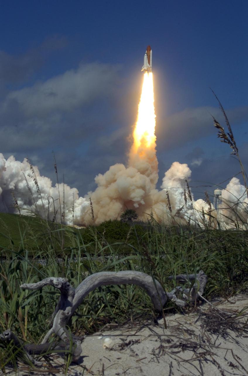 KENNEDY SPACE CENTER, FLA. -   Space Shuttle Atlantis roars into the sky above the primitive sand dunes in the foreground.  Heading  for its rendezvous with the International Space Station on mission STS-115,  liftoff was on-time at 11:14:55 a.m. EDT. After launch attempts were scrubbed Aug. 27 and 29 and Sept. 3 and 8 due to weather and technical concerns,  this launch was executed perfectly.  Mission STS-115 is the 116th space shuttle flight, the 27th flight for orbiter Atlantis, and the 19th U.S. flight to the International Space Station. During the mission, Atlantis' astronauts will deliver and install the 17.5-ton, bus-sized P3/P4 integrated truss segment on the station. The girder-like truss includes a set of giant solar arrays, batteries and associated electronics and will provide one-fourth of the total power-generation capability for the completed station. STS-115 is scheduled to last 11 days with a planned landing at KSC. Photo credit: NASA/Sandra Joseph & Robert Murray