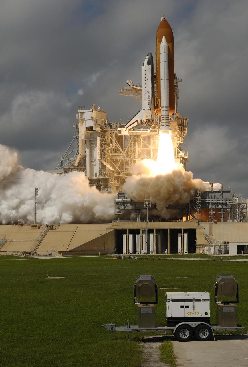 KENNEDY SPACE CENTER, FLA. -   Space Shuttle Atlantis leaps off the launch pad as smoke and steam billow behind it.  Atlantis is heading for space and its rendezvous with the International Space Station on mission STS-115.  Liftoff was on-time at 11:14:55 a.m. EDT.  After several earlier launch attempts were scrubbed due to weather and technical concerns,  this launch was executed perfectly.  Mission STS-115 is the 116th space shuttle flight, the 27th flight for orbiter Atlantis, and the 19th U.S. flight to the International Space Station. During the mission, Atlantis' astronauts will deliver and install the 17.5-ton, bus-sized P3/P4 integrated truss segment on the station. The girder-like truss includes a set of giant solar arrays, batteries and associated electronics and will provide one-fourth of the total power-generation capability for the completed station. STS-115 is scheduled to last 11 days with a planned landing at KSC. Photo courtesy of Nikon/Scott Andrews