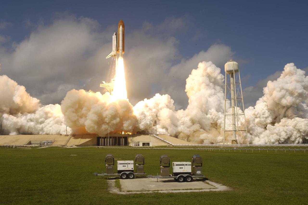 KENNEDY SPACE CENTER, FLA. -   Smoke and steam billow across Launch Pad 39B as Space Shuttle Atlantis hurtles into the sky for its rendezvous with the International Space Station on mission STS-115.  Liftoff was on-time at 11:14:55 a.m. EDT.  After several earlier launch attempts were scrubbed due to weather and technical concerns, this launch was executed perfectly.  Mission STS-115 is the 116th space shuttle flight, the 27th flight for orbiter Atlantis, and the 19th U.S. flight to the International Space Station. During the mission, Atlantis' astronauts will deliver and install the 17.5-ton, bus-sized P3/P4 integrated truss segment on the station. The girder-like truss includes a set of giant solar arrays, batteries and associated electronics and will provide one-fourth of the total power-generation capability for the completed station. STS-115 is scheduled to last 11 days with a planned landing at KSC. Photo courtesy of Nikon/Scott Andrews