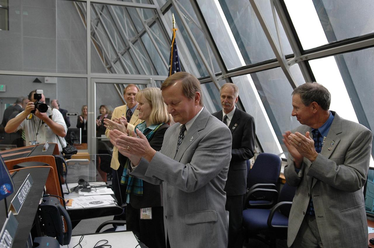 KENNEDY SPACE CENTER, FLA. -  Inside the Launch Control Center, NASA and KSC officials applaud the successful launch of Space Shuttle Atlantis on mission STS-115. From right are NASA Administrator Michael Griffin, Associate Administrator for Space Operations Mission William Gerstenmaier, Shuttle Launch Director Mike Leinbach, NASA Flow Director Angie Brewer, and Public Affairs Officer George Diller, who provided commentary leading up to the launch.  Mission STS-115 is the 116th space shuttle flight, the 27th flight for orbiter Atlantis, and the 19th U.S. flight to the International Space Station. STS-115 is scheduled to last 11 days with a planned landing at KSC. Photo credit: NASA/Kim Shiflett