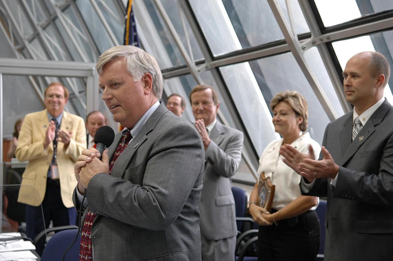 KENNEDY SPACE CENTER, FLA. -  Inside the Launch Control Center, KSC Director Jim Kennedy congratulates the launch team after the liftoff of Space Shuttle Atlantis on mission STS-115.  Behind him are (left to right) Shuttle Launch Director Mike Leinbach, Pat Leslie and Robbie Ashley, STS-115 payload manager.  Mission STS-115 is the 116th space shuttle flight, the 27th flight for orbiter Atlantis, and the 19th U.S. flight to the International Space Station. Mission STS-115 is scheduled to last 11 days with a planned landing at KSC. Photo credit: NASA/Kim Shiflett