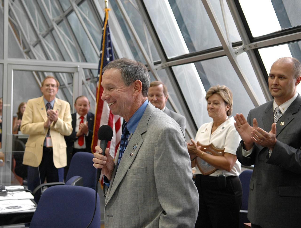 KENNEDY SPACE CENTER, FLA. -  Inside the Launch Control Center, NASA Administrator Michael Griffin congratulates the launch team after the liftoff of Space Shuttle Atlantis on mission STS-115.  Behind him are (left to right) Shuttle Launch Director Mike Leinbach, Pat Leslie and Robbie Ashley, STS-115 payload manager.  Mission STS-115 is the 116th space shuttle flight, the 27th flight for orbiter Atlantis, and the 19th U.S. flight to the International Space Station. Mission STS-115 is scheduled to last 11 days with a planned landing at KSC. Photo credit: NASA/Kim Shiflett