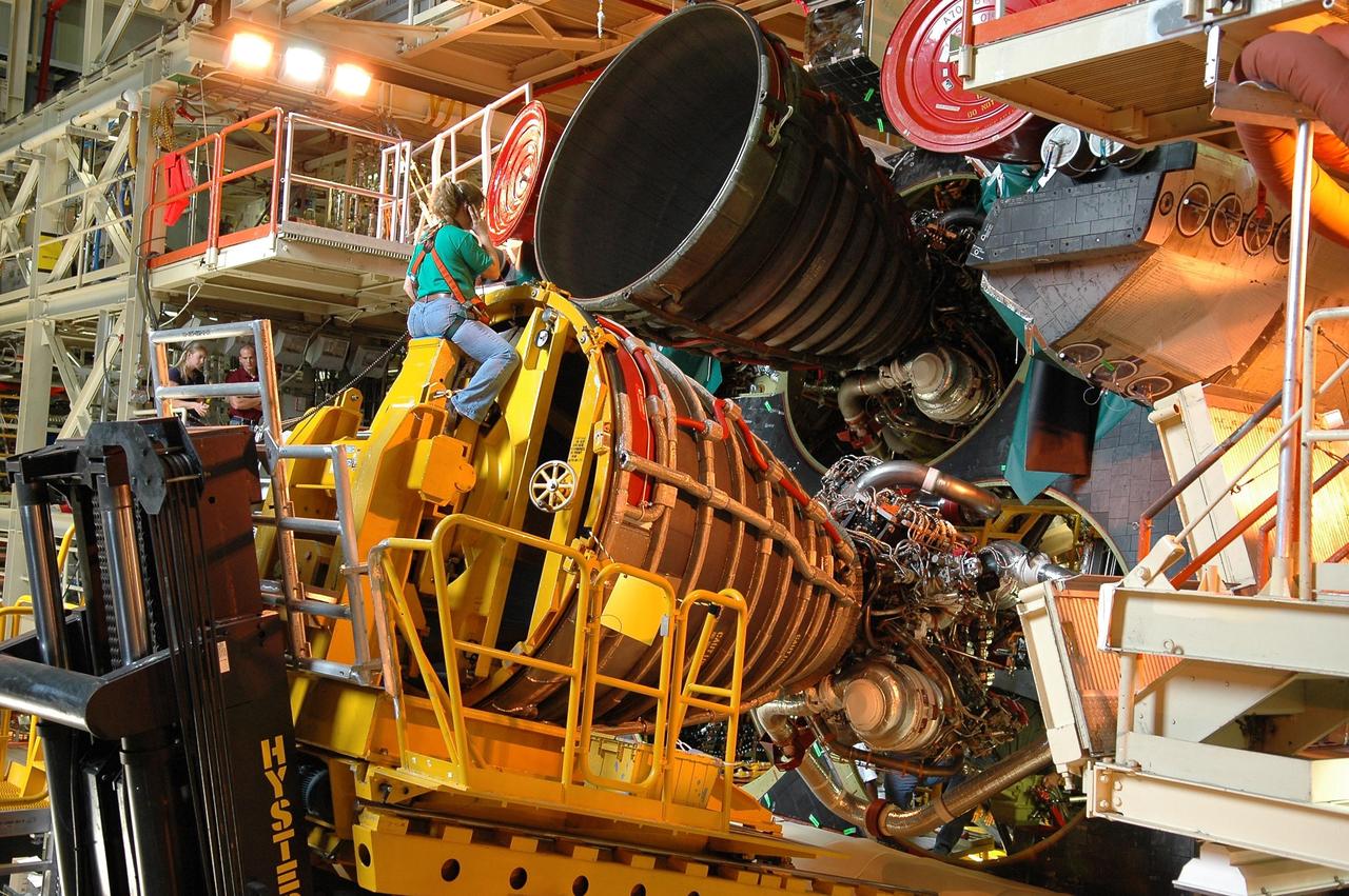 KENNEDY SPACE CENTER, FLA. - In the Orbiter Processing Facility bay 3, technicians on the Hyster forklift maneuver main engine No. 3 into place in Discovery. The main engine configuration is manufactured by Pratt & Whitney Rocketdyne in Canoga Park, Calif., and includes a Pratt & Whitney high-pressure fuel turbo pump. Each space shuttle main engine is 14 feet long, weighs about 6,700 pounds, and is 7.5 feet in diameter at the end of the nozzle. Discovery is being processed for its next mission, STS-116 (12A.1), to deliver a third truss segment, a SPACEHAB module and other key components to the International Space Station. The launch is currently scheduled no earlier than Dec. 14. Photo credit: NASA/Kim Shiflett