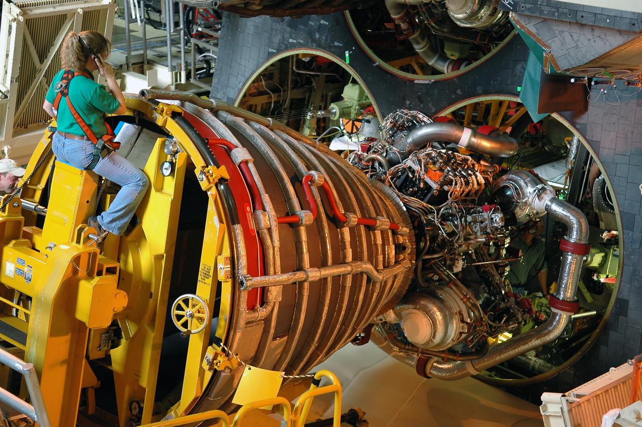 KENNEDY SPACE CENTER, FLA. - In the Orbiter Processing Facility bay 3, technicians on the Hyster forklift maneuver main engine No. 3 into place in Discovery. The main engine configuration is manufactured by Pratt & Whitney Rocketdyne in Canoga Park, Calif., and includes a Pratt & Whitney high-pressure fuel turbo pump. Each space shuttle main engine is 14 feet long, weighs about 6,700 pounds, and is 7.5 feet in diameter at the end of the nozzle. Discovery is being processed for its next mission, STS-116 (12A.1), to deliver a third truss segment, a SPACEHAB module and other key components to the International Space Station. The launch is currently scheduled no earlier than Dec. 14. Photo credit: NASA/Kim Shiflett