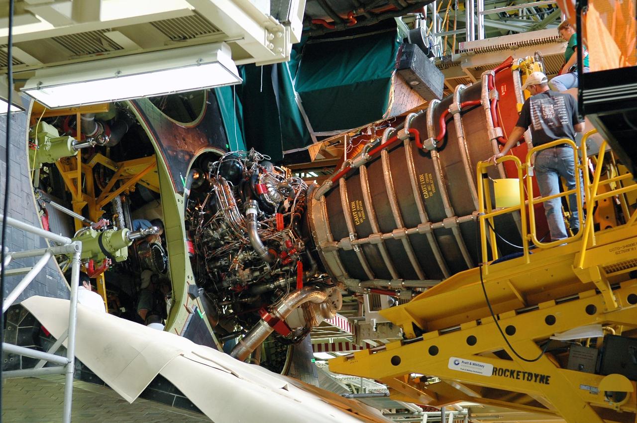 KENNEDY SPACE CENTER, FLA. - In the Orbiter Processing Facility bay 3, technicians on the Hyster forklift maneuver main engine No. 3 into place in Discovery. The main engine configuration is manufactured by Pratt & Whitney Rocketdyne in Canoga Park, Calif., and includes a Pratt & Whitney high-pressure fuel turbo pump. Each space shuttle main engine is 14 feet long, weighs about 6,700 pounds, and is 7.5 feet in diameter at the end of the nozzle. Discovery is being processed for its next mission, STS-116 (12A.1), to deliver a third truss segment, a SPACEHAB module and other key components to the International Space Station. The launch is currently scheduled no earlier than Dec. 14. Photo credit: NASA/Kim Shiflett