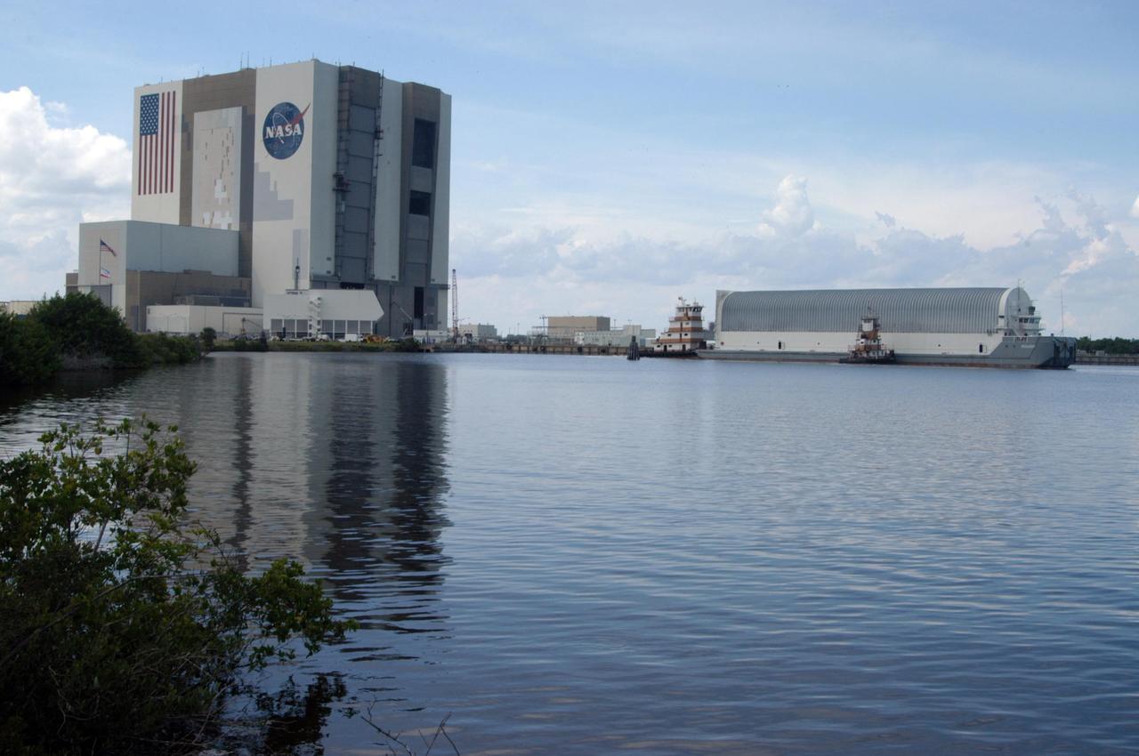 KENNEDY SPACE CENTER, FLA. - The Pegasus barge approaches the turn basin dock in the Launch Complex 39 Area at NASA's Kennedy Space Center. Onboard the barge is the external tank No. 123, designated to launch Space Shuttle Discovery on mission STS-116 in December. At left is the 525-foot-high Vehicle Assembly Building where the external tank will go after offloading from the barge. The tank, which was shipped from NASA's Michoud Assembly Facility in New Orleans, has undergone major safety changes, including removal of the protuberance air load ramps. Mission STS-116 will deliver the P5 truss segment, a SPACEHAB module and other key components to the International Space Station. Launch is currently scheduled no earlier than Dec. 14. Photo credit: NASA/George Shelton