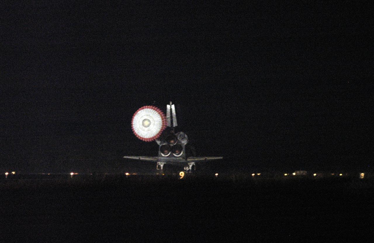 KENNEDY SPACE CENTER, FLA. -   Atlantis releases its drag chute to assist in landing on Runway 33 at NASA's Kennedy Space Center, concluding mission STS-115.  Aboard are Commander Brent Jett, Pilot Christopher Ferguson, and Mission Specialists Joseph Tanner, David Burbank, Heidemarie Stefanyshyn-Piper and Steven MacLean, who represents the Canadian Space Agency.  During the mission, Tanner, McLean, Burbank and Piper completed three spacewalks to attach the P3/P4 integrated truss structure to the International Space Station.  Main gear touchdown was at 6:21:30 a.m. EDT.  Nose gear touchdown was at 6:21:36 a.m. and wheel stop was at 6:22:16 a.m.  At touchdown -- nominally about 2,500 ft. beyond the runway threshold -- the orbiter is traveling at a speed ranging from 213 to 226 mph. Atlantis traveled 4.9 million miles, landing on orbit 187. Mission elapsed time was 11 days, 19 hours, six minutes. This is the 15th night landing at KSC and the 23rd night landing overall.  Photo credit: NASA/Chuck Tintera