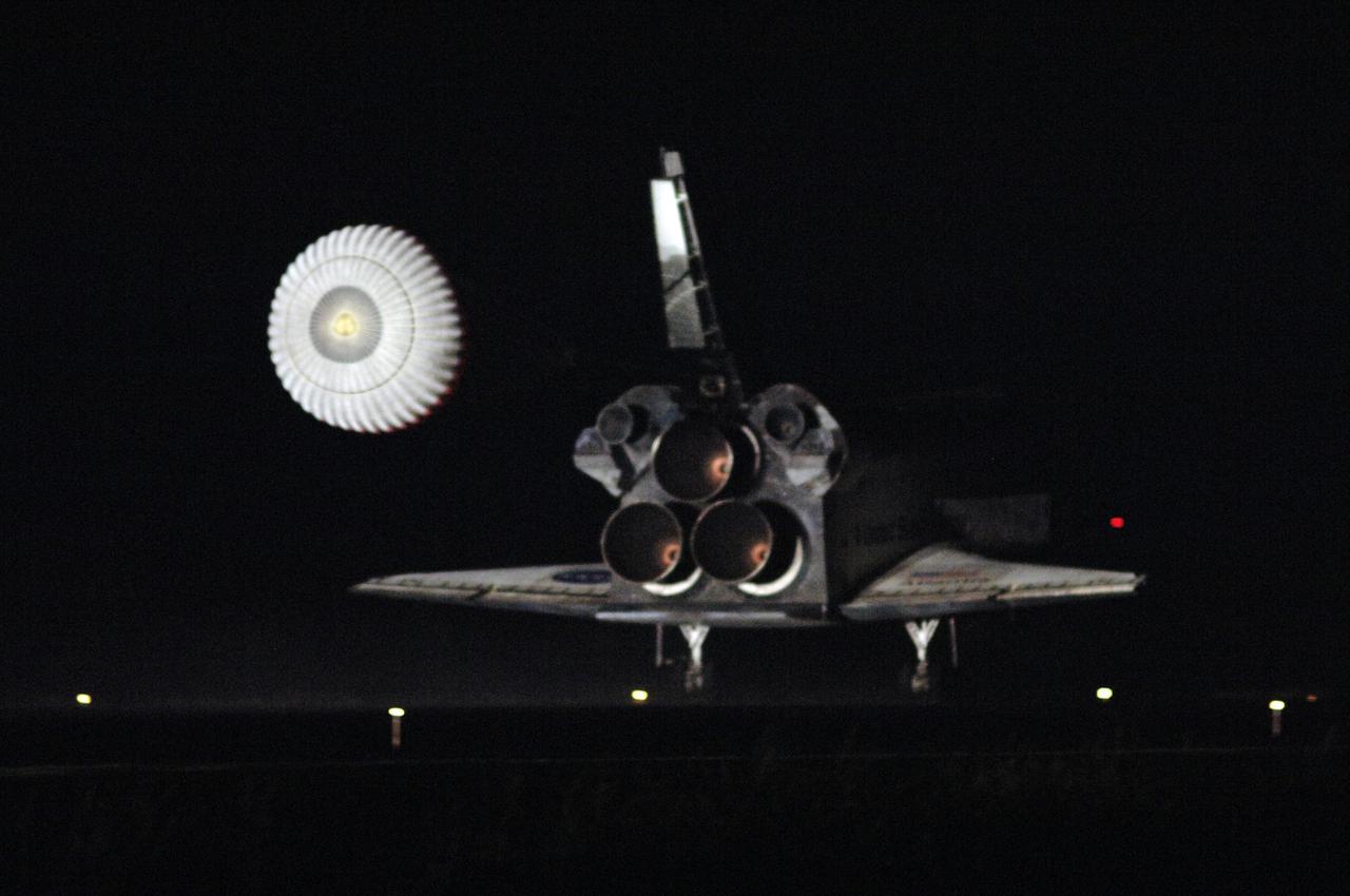 KENNEDY SPACE CENTER, FLA. -   The drag chute glows in the lights illuminating Atlantis as it touches down on Runway 33 at NASA's Kennedy Space Center, concluding mission STS-115.    Aboard are Commander Brent Jett, Pilot Christopher Ferguson, and Mission Specialists Joseph Tanner, David Burbank, Heidemarie Stefanyshyn-Piper and Steven MacLean, who represents the Canadian Space Agency.  During the mission, Tanner, McLean, Burbank and Piper completed three spacewalks to attach the P3/P4 integrated truss structure to the International Space Station.  Main gear touchdown was at 6:21:30 a.m. EDT.  Nose gear touchdown was at 6:21:36 a.m. and wheel stop was at 6:22:16 a.m.  At touchdown -- nominally about 2,500 ft. beyond the runway threshold -- the orbiter is traveling at a speed ranging from 213 to 226 mph. Atlantis traveled 4.9 million miles, landing on orbit 187. Mission elapsed time was 11 days, 19 hours, six minutes. This is the 15th night landing at KSC and the 23rd night landing overall.  Photo credit: NASA/Mike Kerley