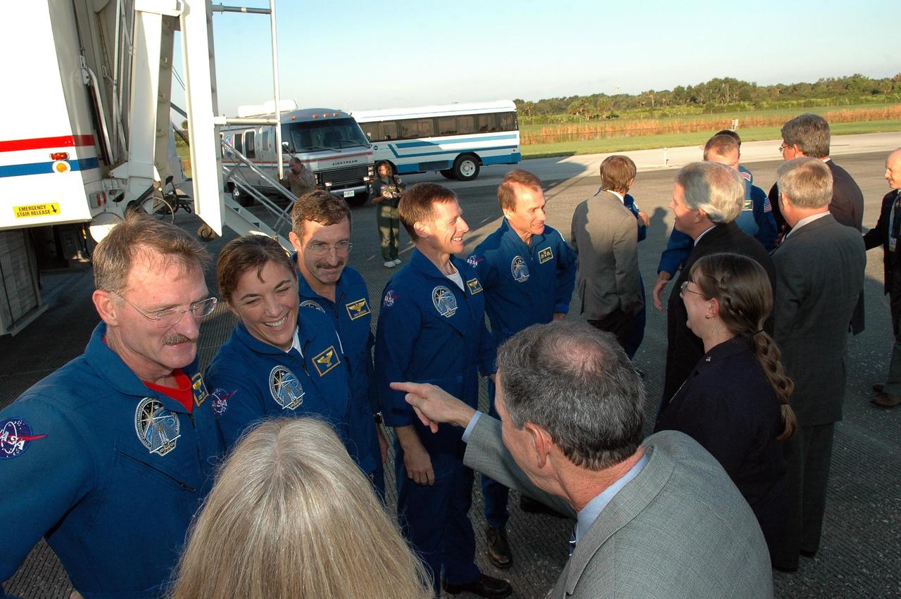 KENNEDY SPACE CENTER, FLA. - After their return from space, the STS-115 crew members are welcomed by NASA and KSC officials.  The crew, from left, are Mission Specialists Joseph Tanner, Heidemarie Stefanyshyn-Piper and Daniel Burbank; Pilot Christopher Ferguson; and Mission Specialist Steven MacLean.  On the right are At right are NASA Administrator Michael Griffin, Deputy Associate Administrator for Space Operations Lynn Cline, a representative of the Canadian Space Agency, KSC Director Jim Kennedy and Deputy Director Bill Parsons.  During the mission, astronauts completed three spacewalks to attach the P3/P4 integrated truss structure to the International Space Station.  Main gear touchdown was at 6:21:30 a.m. EDT.  Nose gear touchdown was at 6:21:36 a.m. and wheel stop was at 6:22:16 a.m. At touchdown -- nominally about 2,500 ft. beyond the runway threshold -- the orbiter is traveling at a speed ranging from 213 to 226 mph. Atlantis traveled 4.9 million miles, landing on orbit 187. Mission elapsed time was 11 days, 19 hours, six minutes. This is the 15th night landing at KSC and the 23rd night landing overall.  Photo credit: NASA/Kim Shiflett