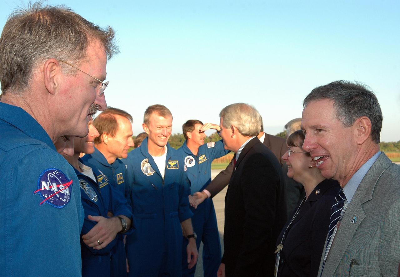 KENNEDY SPACE CENTER, FLA. - After their return from space, the STS-115 crew is welcomed by NASA and KSC officials.  The crew members, from left, are Mission Specialists Joseph Tanner and  Heidemarie Stefanyshyn-Piper; Pilot Christopher Ferguson; Mission Specialist Steven MacLean; Commander Brent Jett; and Mission Specialist Daniel Burbank.  At right are NASA Administrator Michael Griffin, Deputy Associate Administrator for Space Operations Lynn Cline, and a representative of the Canadian Space Agency.  During the mission, astronauts completed three spacewalks to attach the P3/P4 integrated truss structure to the International Space Station.  Main gear touchdown was at 6:21:30 a.m. EDT.  Nose gear touchdown was at 6:21:36 a.m. and wheel stop was at 6:22:16 a.m. At touchdown -- nominally about 2,500 ft. beyond the runway threshold -- the orbiter is traveling at a speed ranging from 213 to 226 mph. Atlantis traveled 4.9 million miles, landing on orbit 187. Mission elapsed time was 11 days, 19 hours, six minutes. This is the 15th night landing at KSC and the 23rd night landing overall.  Photo credit: NASA/Kim Shiflett