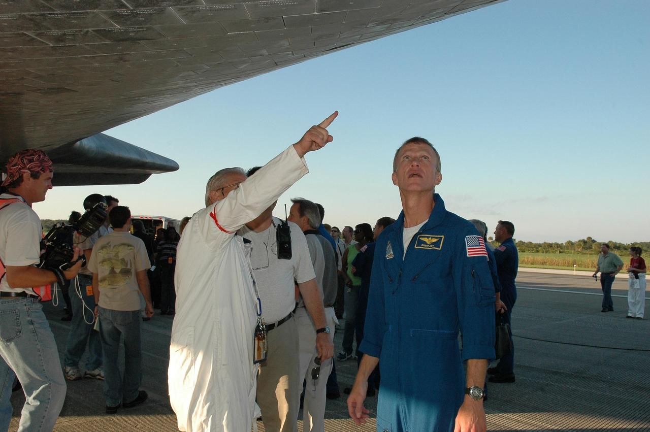 KENNEDY SPACE CENTER, FLA. - After returning from the International Space Station, STS-115 Commander Brent Jett (right) gets a close look at the underside of the orbiter Atlantis at the traditional post-landing inspection.   During the mission, astronauts completed three spacewalks to attach the P3/P4 integrated truss structure to the International Space Station.  Main gear touchdown was at 6:21:30 a.m. EDT.  Nose gear touchdown was at 6:21:36 a.m. and wheel stop was at 6:22:16 a.m.  Atlantis traveled 4.9 million miles, landing on orbit 187. Mission elapsed time was 11 days, 19 hours, six minutes. This is the 15th night landing at KSC and the 23rd night landing overall.  Photo credit: NASA/Kim Shiflett