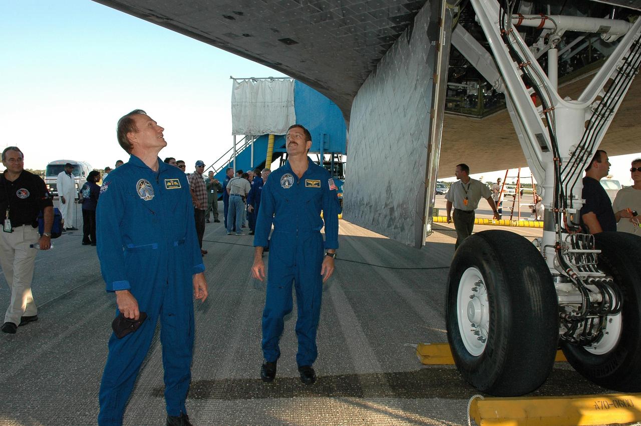 KENNEDY SPACE CENTER, FLA. - At the traditional post-landing inspection, STS-115 Mission Specialists Steven MacLean and Daniel Burbank examine the underside of the orbiter Atlantis.  During the mission, astronauts completed three spacewalks to attach the P3/P4 integrated truss structure to the International Space Station.  Main gear touchdown was at 6:21:30 a.m. EDT.  Nose gear touchdown was at 6:21:36 a.m. and wheel stop was at 6:22:16 a.m.  Atlantis traveled 4.9 million miles, landing on orbit 187. Mission elapsed time was 11 days, 19 hours, six minutes. This is the 15th night landing at KSC and the 23rd night landing overall.  Photo credit: NASA/Kim Shiflett