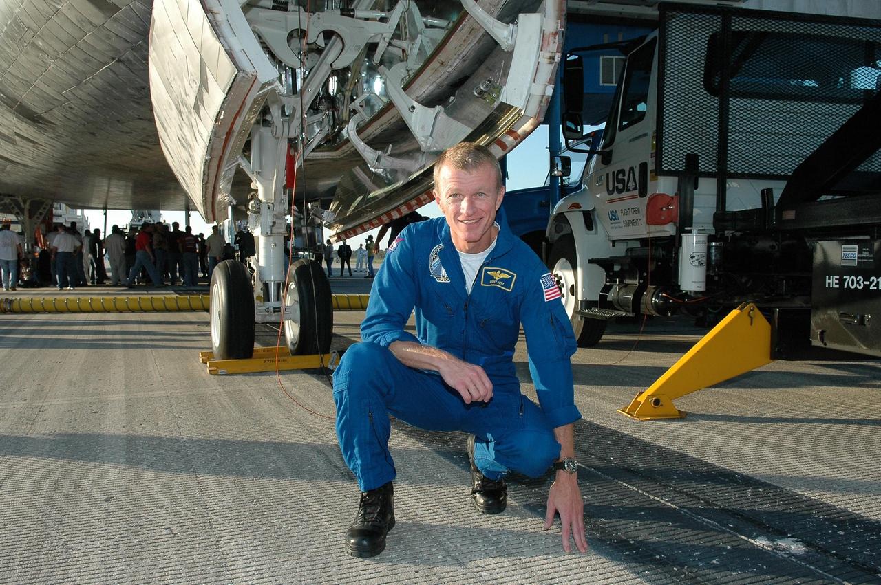 KENNEDY SPACE CENTER, FLA. - After landing safely aboard Atlantis on Runway 33 of the Shuttle Landing Facility, STS-115 Commander Brent Jett is happy to touch Earth again.  He and other crew members are examining the underside of the orbiter Atlantis during the traditional post-landing inspection.During the mission, astronauts completed three spacewalks to attach the P3/P4 integrated truss structure to the International Space Station.  Main gear touchdown was at 6:21:30 a.m. EDT.  Nose gear touchdown was at 6:21:36 a.m. and wheel stop was at 6:22:16 a.m.  Atlantis traveled 4.9 million miles, landing on orbit 187. Mission elapsed time was 11 days, 19 hours, six minutes. This is the 15th night landing at KSC and the 23rd night landing overall.  Photo credit: NASA/Kim Shiflett