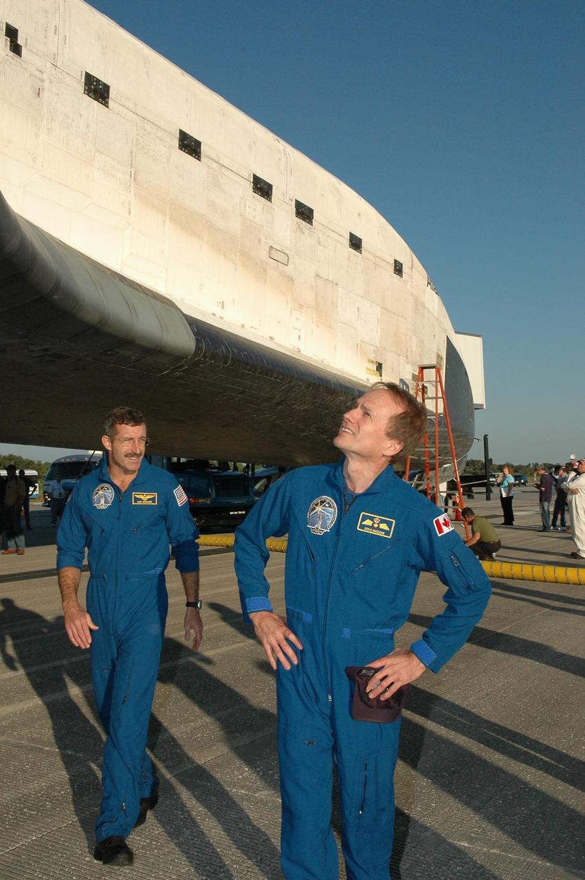 KENNEDY SPACE CENTER, FLA. - At the traditional post-landing inspection, STS-115 Mission Specialists Steven MacLean and Daniel Burbank look over Atlantis.  During the mission, astronauts completed three spacewalks to attach the P3/P4 integrated truss structure to the International Space Station.  Main gear touchdown was at 6:21:30 a.m. EDT.  Nose gear touchdown was at 6:21:36 a.m. and wheel stop was at 6:22:16 a.m.  Atlantis traveled 4.9 million miles, landing on orbit 187. Mission elapsed time was 11 days, 19 hours, six minutes. This is the 15th night landing at KSC and the 23rd night landing overall.  Photo credit: NASA/Kim Shiflett