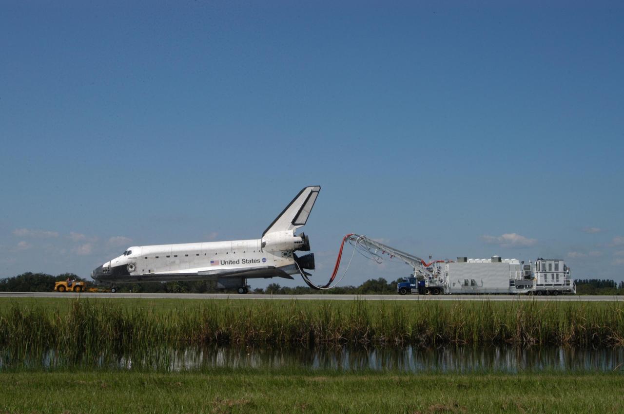 KENNEDY SPACE CENTER, FLA. - With umbilicals still attached, the orbiter Atlantis is being towed from the Shuttle Landing Facility to the Orbiter Processing Facility.  Atlantis landed on Runway 33 at 6:21:30 a.m. EDT after the 11-day, 19-hour, 6-minute mission STS-115 to the International Space Station.  Atlantis traveled 4.9 million miles, landing on orbit 187. During the mission, astronauts delivered and installed the massive P3/P4 truss, an integral part of the station's backbone, and two sets of solar arrays that will eventually provide one quarter of the station's power. In the OPF, the process flow will begin to ready the vehicle for its next flight.  Photo credit: NASA/George Shelton