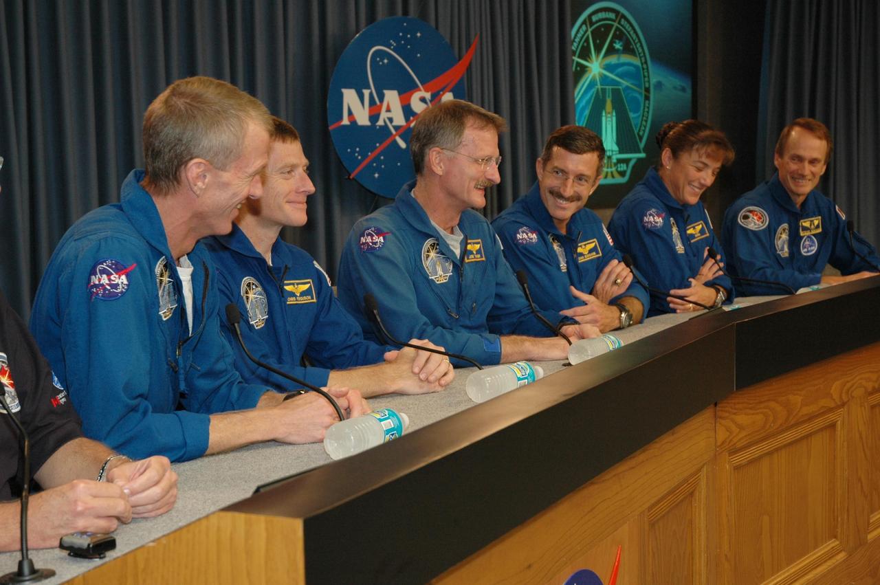 KENNEDY SPACE CENTER, FLA. -  At a post-landing press conference at NASA's Kennedy Space Center, the STS-115 crew members smile at a question from the media.  Seated from left are Commander Brent Jett, Pilot Christopher Ferguson, and Mission Specialists Joseph Tanner, Daniel Burbank, Heidemarie Stefanyshyn-Piper and Steven MacLean, who represents the Canadian Space Agency.  During the mission to the International Space Station, astronauts delivered and installed the massive P3/P4 truss, an integral part of the station's backbone, and two sets of solar arrays that will eventually provide one quarter of the station's power. After 11 days, 19 hours and 6 minutes in space, the crew returned to Earth aboard Atlantis at 6:21:30 a.m. EDT.   Photo credit: NASA/Cory Huston