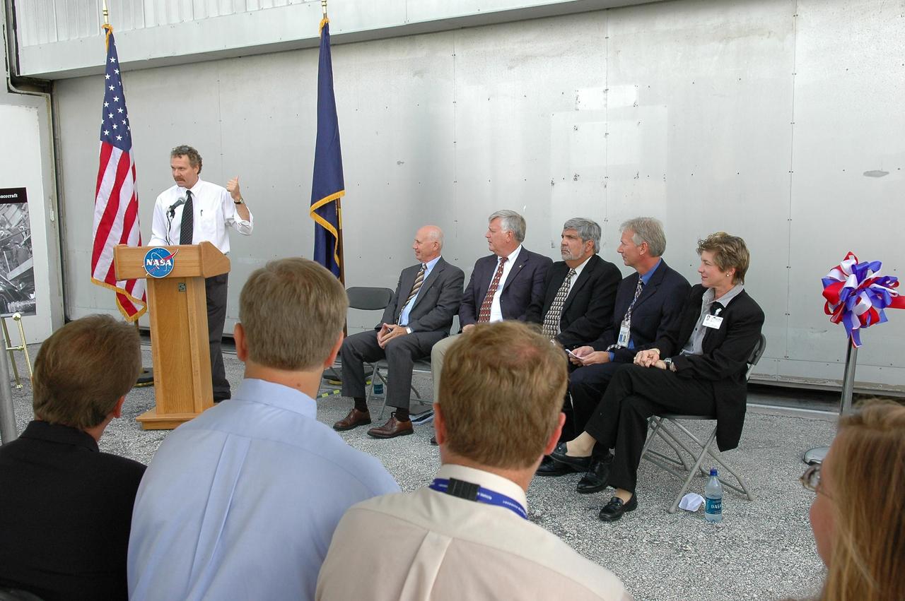 KENNEDY SPACE CENTER, FLA. - A ribbon-cutting at NASA's Kennedy Space Center officially reactivated the Operations and Checkout Building's west door as entry to the crew exploration vehicle environment. At the podium is Russell Romanella, who opened the ceremony. Romanella is director of the ISS Payload and Processing Directorate. Seated at right are Conrad Nagel, consultant for Space Florida; Jim Kennedy, director of KSC; Adrian Lafitte, director of government relations for Lockheed Martin; Mark Jager, program manager of Checkout, Assembly, Payloads Processing Services with Boeing; and Lynda Weatherman, with the Economic Development Commission. During the rest of the decade, KSC will transition from launching space shuttles to launching new vehicles in NASA’s Vision For Space Exploration. Photo credit: NASA/Kim Shiflett
