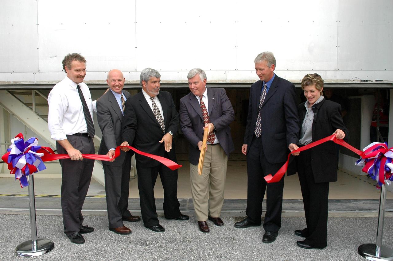 KENNEDY SPACE CENTER, FLA. - NASA officials cut the ribbon to officially reactivate the Operations and Checkout Building's west door as entry to the crew exploration vehicle (CEV) environment. From left are Russell Romanella, director of the ISS Payload and Processing Directorate; Conrad Nagel, consultant for Space Florida; Jim Kennedy, director of KSC; Adrian Lafitte, director of government relations for Lockheed Martin; Mark Jager, program manager of Checkout, Assembly, Payloads Processing Services with Boeing; and Lynda Weatherman, with the Economic Development Commission. During the rest of the decade, KSC will transition from launching space shuttles to launching new vehicles in NASA’s Vision For Space Exploration. Photo credit: NASA/Kim Shiflett