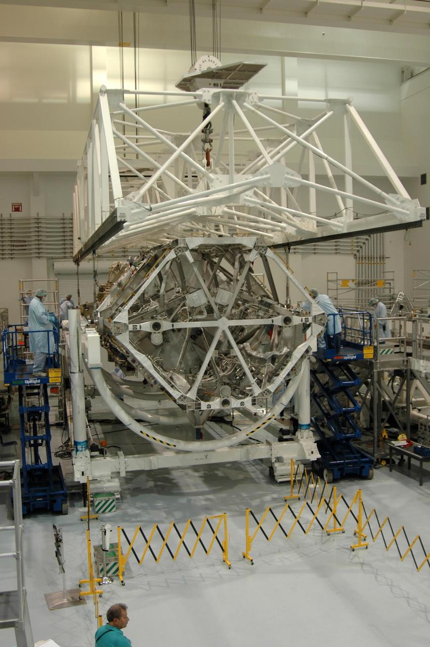 KENNEDY SPACE CENTER, FLA. - In the Space Station Processing Facility, an overhead crane is being attached to the S3/S4 integrated truss structure in order to move it from a rotation stand to a work stand. Along with a third set of solar arrays and batteries, the truss is scheduled to fly on mission STS-117 aboard Space Shuttle Atlantis to the International Space Station. The crew of six astronauts will install the truss to continue assembly of the station. Photo credit: NASA/Dimitri Gerondidakis