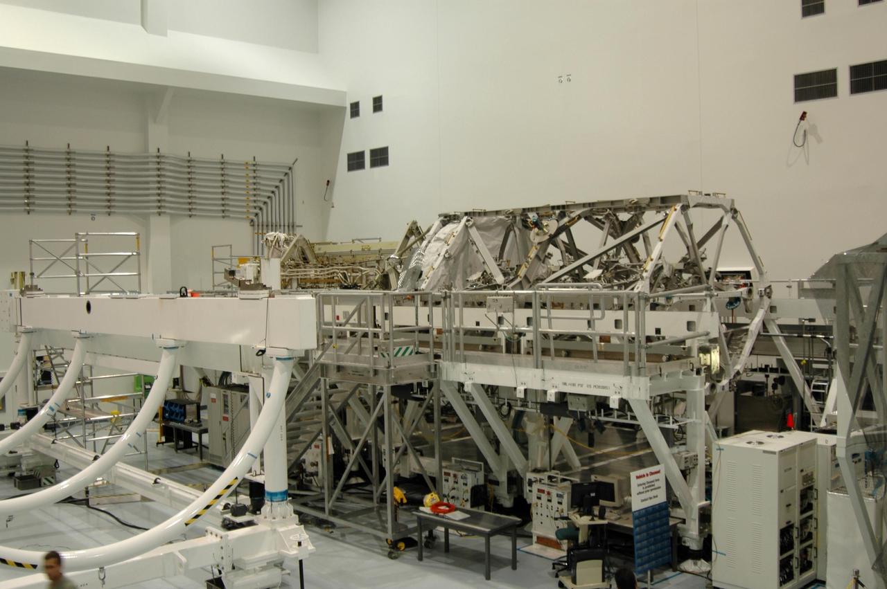 KENNEDY SPACE CENTER, FLA. -  In the Space Station Processing Facility, the S3/S4 integrated truss structure  (background, right) rests on a work stand.  It was moved from a rotation stand at left.  Along with a third set of solar arrays and batteries, the truss is scheduled to fly on mission STS-117 aboard Space Shuttle Atlantis to the International Space Station. The crew of six astronauts will install the truss to continue assembly of the station.  Photo credit: NASA/Dimitri Gerondidakis