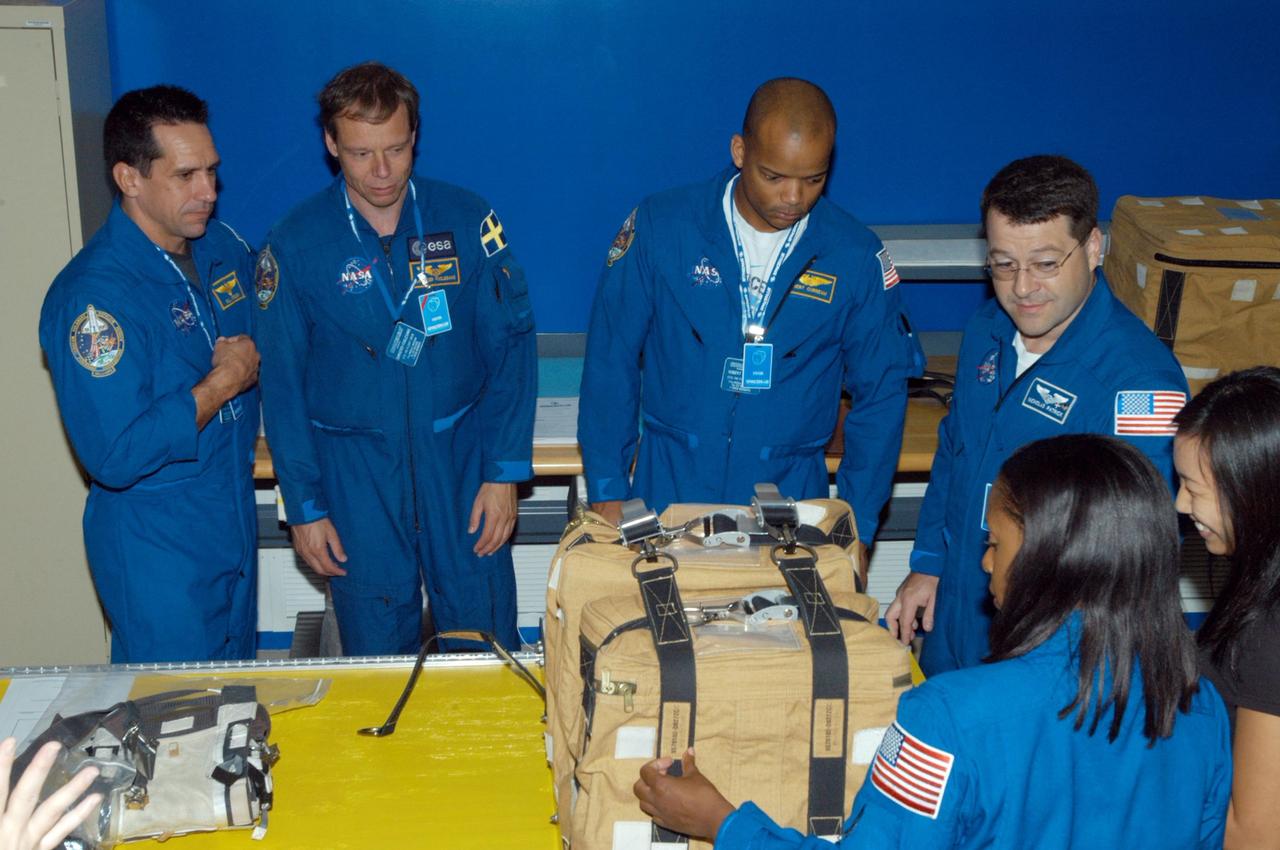 KENNEDY SPACE CENTER, FLA. -  Members of the STS-116 crew examine components of the mission payload at SPACEHAB in Cape Canaveral, Fla.  Looking at a stowage bag are, clockwise from left,  Pilot William Ofelein and Mission Specialists Christer Fuglesang, Robert Curbeam, Nicholas Patrick and Joan Higginbotham.  The Swedish Fuglesang represents the European Space Agency. Mission crews make frequent trips to the Space Coast to become familiar with the equipment and payloads they will be using.  STS-116 will be mission number 20 to the International Space Station and construction flight 12A.1.  The mission payload is the SPACEHAB module, the P5 integrated truss structure and other key components.   Launch is scheduled for no earlier than Dec. 7.  Photo credit: NASA/George Shelton