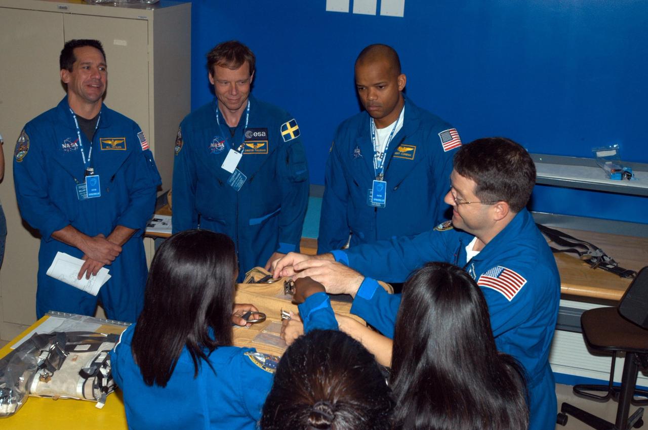KENNEDY SPACE CENTER, FLA. -  Members of the STS-116 crew examine components of the mission payload at SPACEHAB in Cape Canaveral, Fla.  From left are Pilot William Ofelein and Mission Specialists Christer Fuglesang, Robert Curbeam and Nicholas Patrick.  In the foreground at left is Mission Specialist Joan Higginbotham.  The Swedish Fuglesang represents the European Space Agency.  They are practicing opening a stowage bag.  Mission crews make frequent trips to the Space Coast to become familiar with the equipment and payloads they will be using.  STS-116 will be mission number 20 to the International Space Station and construction flight 12A.1.  The mission payload is the SPACEHAB module, the P5 integrated truss structure and other key components.   Launch is scheduled for no earlier than Dec. 7.  Photo credit: NASA/George Shelton