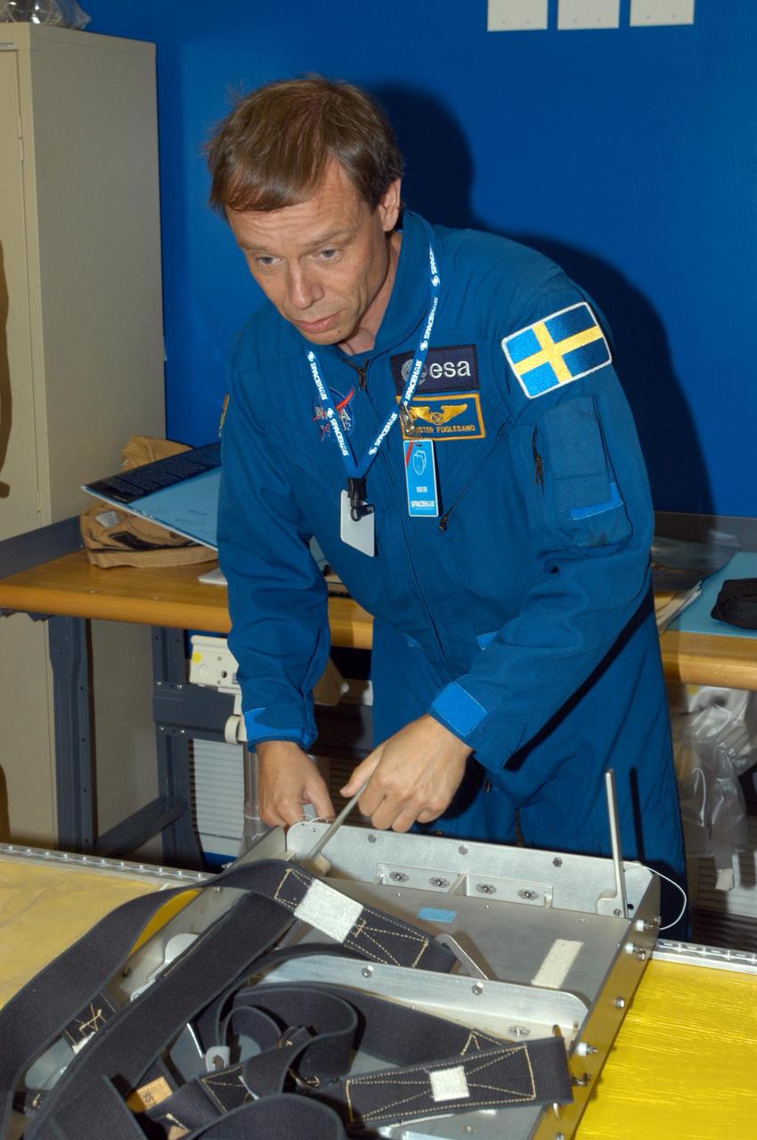 KENNEDY SPACE CENTER, FLA. -  At SPACEHAB in Cape Canaveral, Fla., STS-116 Mission Specialist Christer Fuglesang  practices techniques for removing and replacing the rack front stowage tray,  used inside the SPACEHAB module.  Fuglesang , from Sweden,  represents the European Space Agency.  Mission crews make frequent trips to the Space Coast to become familiar with the equipment and payloads they will be using.  STS-116 will be mission number 20 to the International Space Station and construction flight 12A.1.  The mission payload is the SPACEHAB module, the P5 integrated truss structure and other key components.   Launch is scheduled for no earlier than Dec. 7.  Photo credit: NASA/George Shelton