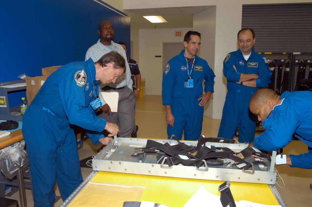 KENNEDY SPACE CENTER, FLA. -  Members of the STS-116 crew examine components of the mission payload at SPACEHAB in Cape Canaveral, Fla.  From left are Mission Specialist Christer Fuglesang , Pilot William Oefelein, Commander Mark Polansky and Mission Specialist Robert Curbeam.   Fuglesang, who represents the European Space Agency, and Curbeam practice techniques for removing and replacing the rack front stowage tray, used inside the SPACEHAB module.  Mission crews make frequent trips to the Space Coast to become familiar with the equipment and payloads they will be using.  STS-116 will be mission number 20 to the International Space Station and construction flight 12A.1.  The mission payload is the SPACEHAB module, the P5 integrated truss structure and other key components.   Launch is scheduled for no earlier than Dec. 7.  Photo credit: NASA/George Shelton