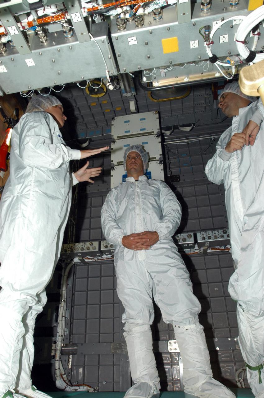 KENNEDY SPACE CENTER, FLA. -  At SPACEHAB in Cape Canaveral, Fla., STS-116 Pilot William Oefelein (center) and Commander Mark Polansky (right) listen to information about the contents of the SPACEHAB module they are standing in.  Mission crews make frequent trips to the Space Coast to become familiar with the equipment and payloads they will be using.  STS-116 will be mission number 20 to the International Space Station and construction flight 12A.1.  The mission payload is the SPACEHAB module, the P5 integrated truss structure and other key components.   Launch is scheduled for no earlier than Dec. 7.  Photo credit: NASA/George Shelton