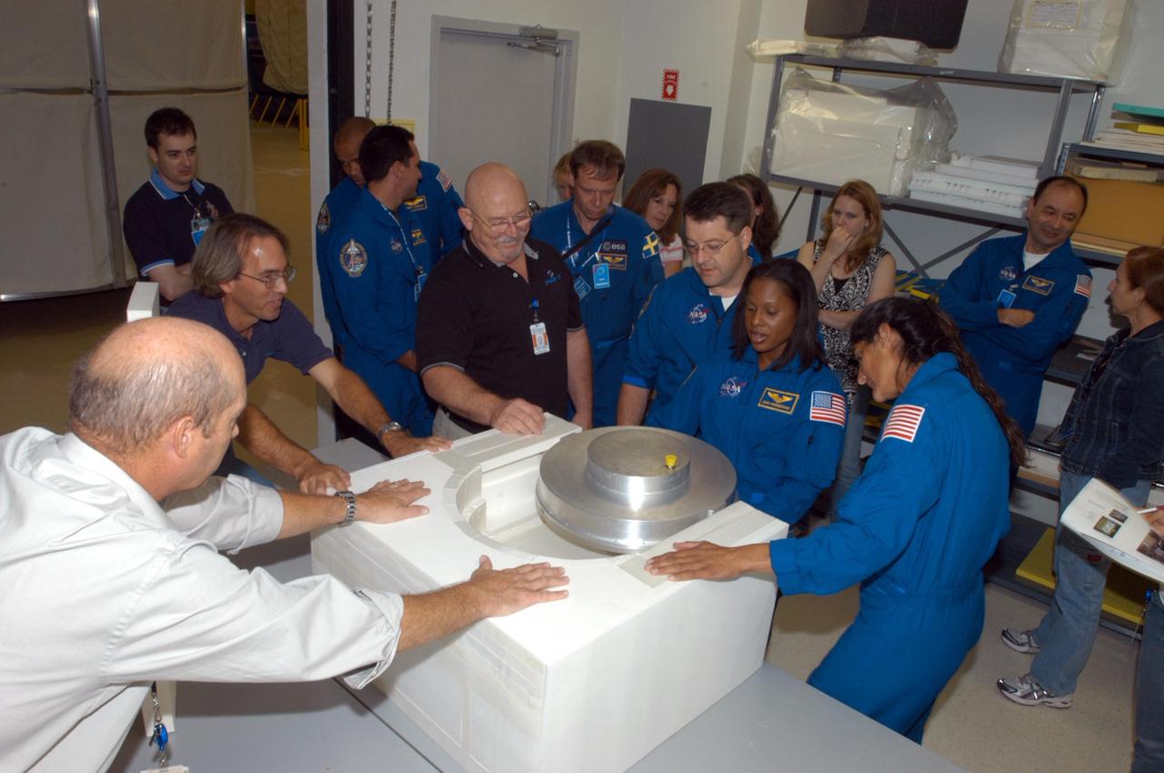 KENNEDY SPACE CENTER, FLA. -  At SPACEHAB in Cape Canaveral, Fla., STS-116  crew members get a close look at the Treadmill Vibration Isolation System Gyroscope during equipment familiarization. The block of foam is what the replacement gyro will be stowed in inside the SPACEHAB module.  In uniform from left are Pilot William Oefelein and Mission Specialists Christer Fuglesang, Nicholas Patrick, Joan Higginbotham and Sunita Williams.  In the background at right is Commander Mark Polansky. Fuglesang, from Sweden,  represents the European Space Agency.  Mission crews make frequent trips to the Space Coast to become familiar with the equipment and payloads they will be using.  STS-116 will be mission number 20 to the International Space Station and construction flight 12A.1.  The mission payload is the SPACEHAB module, the P5 integrated truss structure and other key components.   Launch is scheduled for no earlier than Dec. 7.  Photo credit: NASA/George Shelton