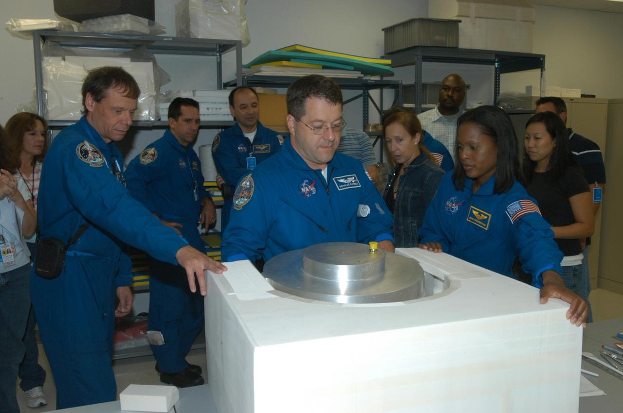 KENNEDY SPACE CENTER, FLA. -  At SPACEHAB in Cape Canaveral, Fla., STS-116  crew members get a close look at he Treadmill Vibration Isolation System Gyroscop during equipment familiarization.  Mission Specialist Nicholas Patrick (center) practices stowing the replacement gyro in the block of foam which is what the gyro will be stowed in inside the SPACEHAB module. The other crew members watching are, from left, Mission Specialists Christer Fuglesang,  Pilot William Oefelein, Commander Mark Polansky, and at right, Mission Specialist Joan Higginbotham.  Fuglesang, from Sweden,  represents the European Space Agency.  Between Patarick and Higginbotham is astronaut Marsha Ivins, who is currently assigned to the Astronaut Office, Space Station/Shuttle Branches for crew equipment, habitability and stowage.  Mission crews make frequent trips to the Space Coast to become familiar with the equipment and payloads they will be using.  STS-116 will be mission number 20 to the International Space Station and construction flight 12A.1.  The mission payload is the SPACEHAB module, the P5 integrated truss structure and other key components.   Launch is scheduled for no earlier than Dec. 7.  Photo credit: NASA/George Shelton