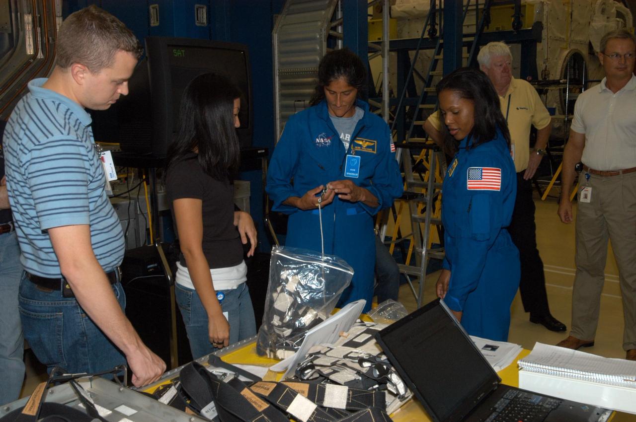 KENNEDY SPACE CENTER, FLA. -  At SPACEHAB in Cape Canaveral, Fla., STS-116 Mission Specialists Sunita Williams (left) and Joan Higginbotham get a close look at the rack front stowage trays that are used inside the SPACEHAB module.   Mission crews make frequent trips to the Space Coast to become familiar with the equipment and payloads they will be using.  STS-116 will be mission number 20 to the International Space Station and construction flight 12A.1.  The mission payload is the SPACEHAB module, the P5 integrated truss structure and other key components.   Launch is scheduled for no earlier than Dec. 7.  Photo credit: NASA/George Shelton