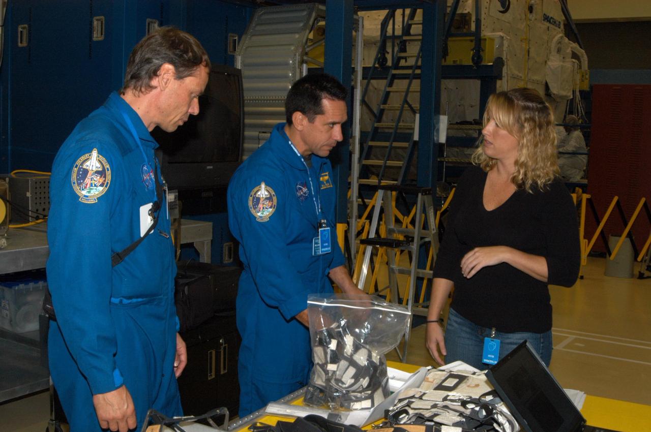 KENNEDY SPACE CENTER, FLA. - At SPACEHAB in Cape Canaveral, Fla., STS-116 Mission Specialist Christer Fuglesang (left) and Pilot William Oefelein look at the rack front stowage trays that are used inside the SPACEHAB module. Mission crews make frequent trips to the Space Coast to become familiar with the equipment and payloads they will be using. STS-116 will be mission number 20 to the International Space Station and construction flight 12A.1. The mission payload is the SPACEHAB module, the P5 integrated truss structure and other key components. Launch is scheduled for no earlier than Dec. 7. Photo credit: NASA/George Shelton