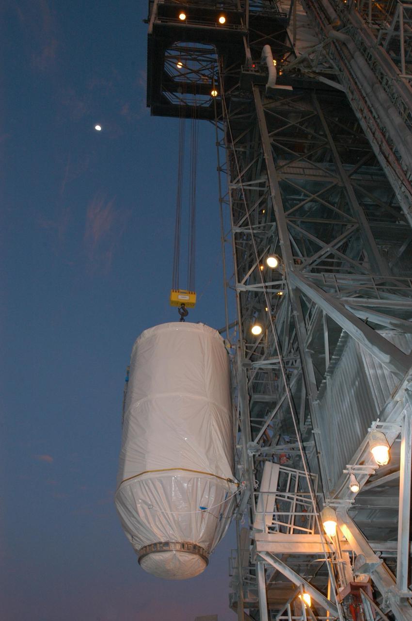 KENNEDY SPACE CENTER, FLA. - Against a pre-dawn sky on Launch Pad 17-B at Cape Canaveral Air Force Station, the STEREO spacecraft is lifted alongside the mobile service tower. In the tower, STEREO will be mated with its launch vehicle, a Boeing Delta II rocket. STEREO stands for Solar Terrestrial Relations Observatory and comprises two spacecraft. The STEREO mission is the first to take measurements of the sun and solar wind in 3-dimension. This new view will improve our understanding of space weather and its impact on the Earth. The STEREO mission is managed by Goddard Space Flight Center. The Applied Physics Laboratory designed and built the spacecraft. The laboratory will maintain command and control of the observatories throughout the mission, while NASA tracks and receives the data, determines the orbit of the satellites, and coordinates the science results. STEREO is expected to lift off Oct. 25. Photo credit: NASA/George Shelton
