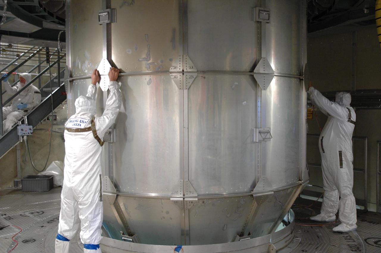 KENNEDY SPACE CENTER, FLA. - Inside the mobile service tower on Launch Pad 17-B at Cape Canaveral Air Force Station, workers unlatch the transportation canister segments that enclose the STEREO spacecraft. The spacecraft is being prepared for launch, scheduled for Oct. 25. STEREO stands for Solar Terrestrial Relations Observatory and comprises two spacecraft that will launch in a piggyback mode, separating after reaching the appropriate orbit. The STEREO mission is the first to take measurements of the sun and solar wind in 3-dimension. This new view will improve our understanding of space weather and its impact on the Earth. The STEREO mission is managed by Goddard. The Applied Physics Laboratory designed and built the spacecraft. The laboratory will maintain command and control of the observatories throughout the mission, while NASA tracks and receives the data, determines the orbit of the satellites, and coordinates the science results. Photo credit: NASA/Jim Grossmann