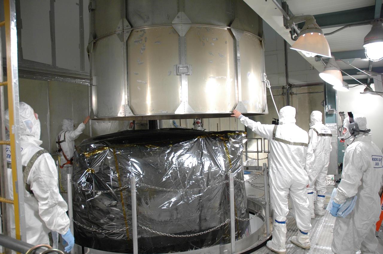 KENNEDY SPACE CENTER, FLA. - Inside the mobile service tower on Launch Pad 17-B at Cape Canaveral Air Force Station, workers help guide the upper segement of the transportation canister away from the STEREO spacecraft. STEREO is being prepared for launch, scheduled for Oct. 25. STEREO stands for Solar Terrestrial Relations Observatory and comprises two spacecraft that will launch in a piggyback mode, separating after reaching the appropriate orbit. The STEREO mission is the first to take measurements of the sun and solar wind in 3-dimension. This new view will improve our understanding of space weather and its impact on the Earth. The STEREO mission is managed by Goddard. The Applied Physics Laboratory designed and built the spacecraft. The laboratory will maintain command and control of the observatories throughout the mission, while NASA tracks and receives the data, determines the orbit of the satellites, and coordinates the science results. Photo credit: NASA/Jim Grossmann