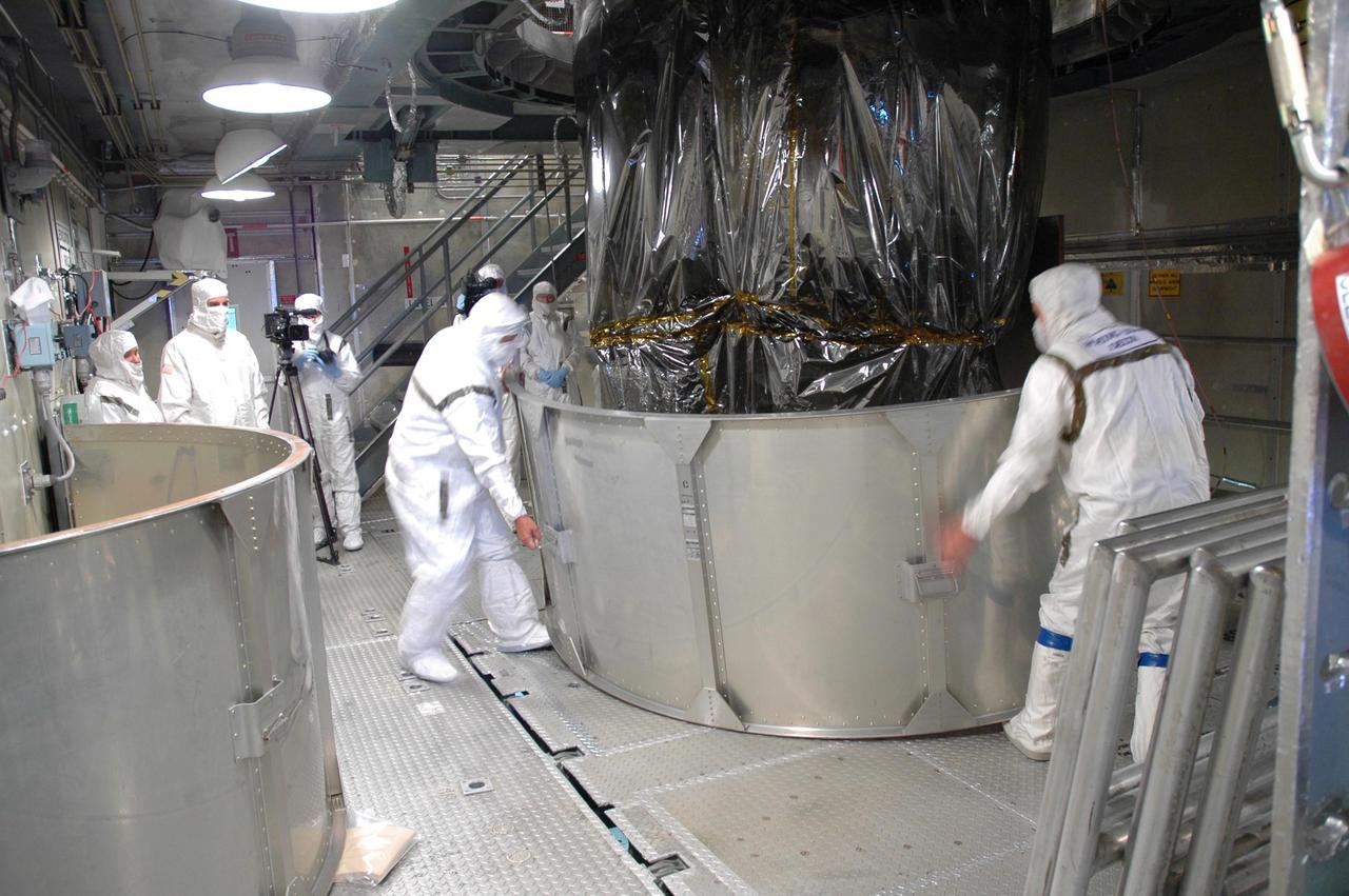 KENNEDY SPACE CENTER, FLA. - Inside the mobile service tower on Launch Pad 17-B at Cape Canaveral Air Force Station, workers begin removing the lower segment of the transportation canister that encloses the STEREO spacecraft. The spacecraft is being prepared for launch, scheduled for Oct. 25. STEREO stands for Solar Terrestrial Relations Observatory and comprises two spacecraft that will launch in a piggyback mode, separating after reaching the appropriate orbit. The STEREO mission is the first to take measurements of the sun and solar wind in 3-dimension. This new view will improve our understanding of space weather and its impact on the Earth. The STEREO mission is managed by Goddard. The Applied Physics Laboratory designed and built the spacecraft. The laboratory will maintain command and control of the observatories throughout the mission, while NASA tracks and receives the data, determines the orbit of the satellites, and coordinates the science results. Photo credit: NASA/Jim Grossmann