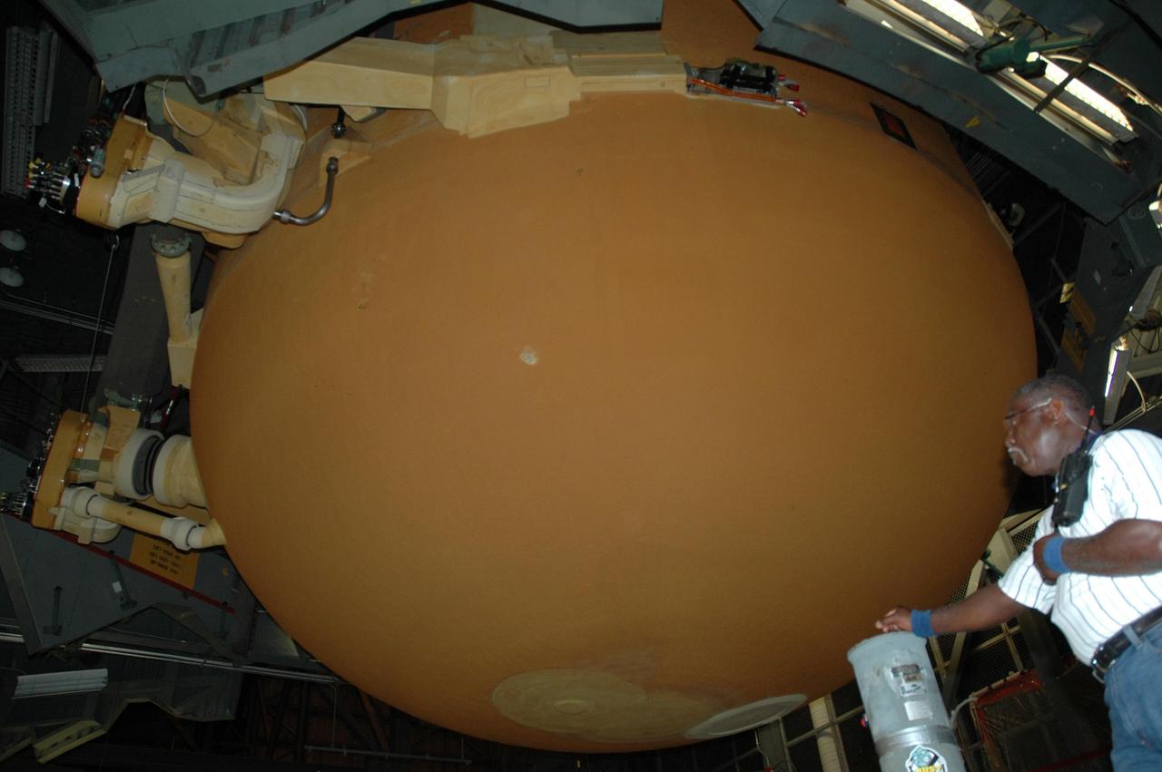 KENNEDY SPACE CENTER, FLA. - Inside the Vehicle Assembly Building, workers prepare to transfer the external tank from the checkout cell for attaching to its twin solid rocket boosters on the mobile launch platform in highbay 3 for mission STS-116. The gigantic, rust-colored external tank is the largest element of the Space Shuttle system at 27.6-feet wide and 154-feet tall. STS-116 will be mission no. 20 to the International Space Station and construction flight 12A.1. The mission payload is the SPACEHAB module, the P5 integrated truss structure and other key components. Launch is scheduled for no earlier than Dec. 7. Photo credit: NASA/Jack Pfaller