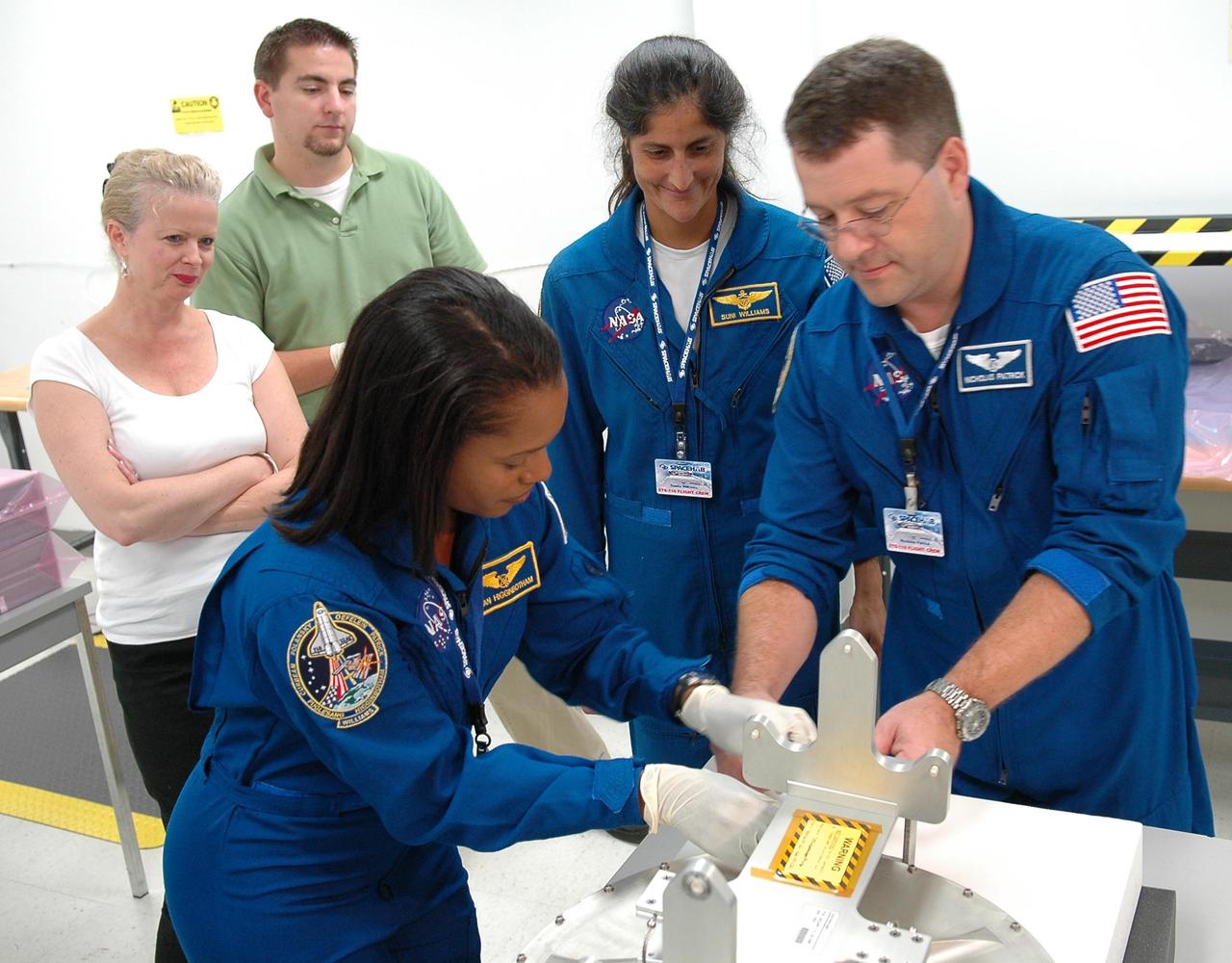 KENNEDY SPACE CENTER, FLA. -    Inside the SPACEHAB Payload Processing Facility at Port Canaveral, Fla., STS-116 Mission Specialists (from left) Joan Higginbotham, Sunita Williams and Nicholas Patrick look over flight hardware during the Crew Equipment Interface Test.  Mission crews make frequent trips to the Space Coast to become familiar with the equipment and payloads they will be using. STS-116 will be mission No. 20 to the International Space Station and construction flight 12A.1. The mission payload is the SPACEHAB module, the P5 integrated truss structure and other key components.  Launch is scheduled for no earlier than Dec. 7.  Photo credit: NASA/Kim Shiflett