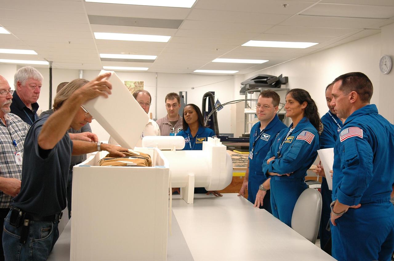 KENNEDY SPACE CENTER, FLA. - Inside the SPACEHAB Payload Processing Facility, at Port Canaveral, Fla., mission STS-116 crew members inspect flight hardware during the Crew Equipment Interface Test. From left are Mission Specialists Joan Higgenbotham, Nicholas Patrick, Sunita Williams and Christer Fuglesang, who is with the European Space Agency. Behind Fuglesang is Commander Mark Polansky. Mission crews make frequent trips to the Space Coast to become familiar with the equipment and payloads they will be using. STS-116 will be mission No. 20 to the International Space Station and construction flight 12A.1. The mission payload is the SPACEHAB module, the P5 integrated truss structure and other key components. Launch is scheduled for no earlier than Dec. 7. Photo credit: NASA/Kim Shiflett