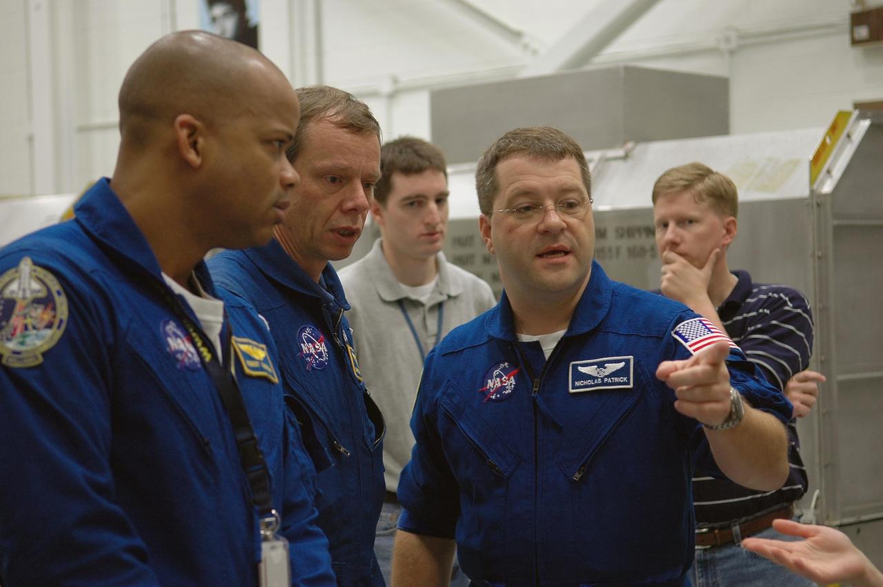 KENNEDY SPACE CENTER, FLA. -   In the Orbiter Processing Facility, members of the STS-116 crew discuss use of some of the flight hardware during the Crew Equipment Interface Test.  Seen here are (from left) Mission Specialists Robert Curbeam, Christer Fugelsang and Nicholas Patrick.  Fugelsang represents the European Space Agency. Mission crews make frequent trips to the Kennedy Space Center to become familiar with the equipment and payloads they will be using.  STS-116 will be mission No. 20 to the International Space Station and construction flight 12A.1.  The mission payload is the SPACEHAB module, the P5 integrated truss structure and other key components.   Launch is scheduled for no earlier than Dec. 7.  Photo credit: NASA/Kim Shiflett