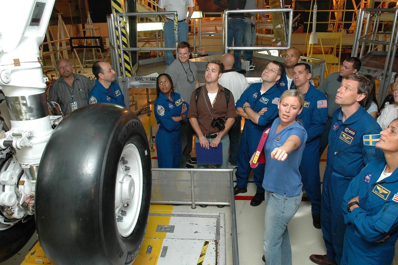 KENNEDY SPACE CENTER, FLA. -    In the Orbiter Processing Facility, STS-116 crew members get a close look at the underside of the orbiter Discovery.  The astronauts are, from left, Commander Mark Polansky, Mission Specialists Joan Higginbotham and Nicholas Patrick, Pilot William Oefelein, and Mission Specialists Christer Fugelsang, who represents the European Space Agency, and Sunita Williams. The crew is at KSC for a Crew Equipment Interface Test.  Mission crews make frequent trips to the Kennedy Space Center to become familiar with the equipment and payloads they will be using.  STS-116 will be mission No. 20 to the International Space Station and construction flight 12A.1.  The mission payload is the SPACEHAB module, the P5 integrated truss structure and other key components.   Launch is scheduled for no earlier than Dec. 7.  Photo credit: NASA/Kim Shiflett