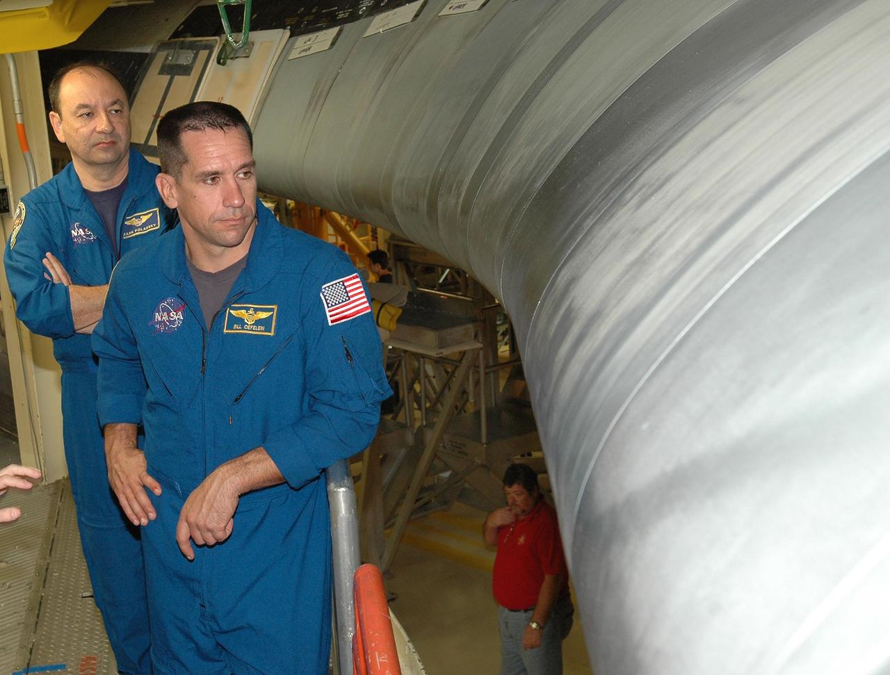 KENNEDY SPACE CENTER, FLA. - From a platform in the Orbiter Processing Facility, STS-116 Commander Mark Polansky (left) and Pilot William Oefelein look at one of Discovery’s reinforced carbon-carbon wing leading edge. They and other crew members are at KSC for a Crew Equipment Interface Test. Mission crews make frequent trips to the Kennedy Space Center to become familiar with the equipment and payloads they will be using. STS-116 will be mission No. 20 to the International Space Station and construction flight 12A.1. The mission payload is the SPACEHAB module, the P5 integrated truss structure and other key components. Launch is scheduled for no earlier than Dec. 7. Photo credit: NASA/Kim Shiflett